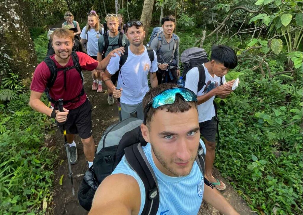 Mount Rinjani trekking join group with backpackers enjoying walking through lush tropical rain forests