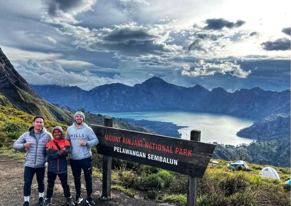 Panoramic view from Sembalun Crater Rim on Mount Rinjani overlooking Segara Anak lake and volcanic landscape at sunrise